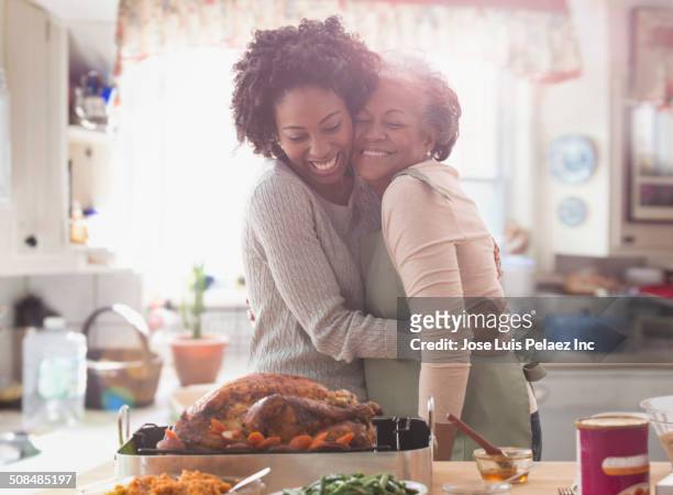 mother and daughter cooking together in kitchen - mother daughter kitchen stockfoto's en -beelden