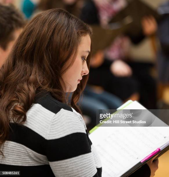 choir singer reading sheet music on stage - choir stage stockfoto's en -beelden