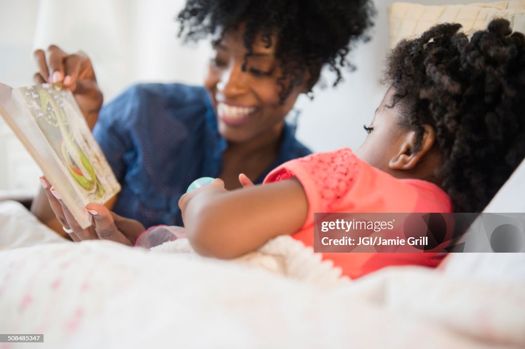 Mother and daughter reading in bed