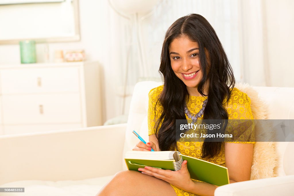 Hispanic woman writing in notebook