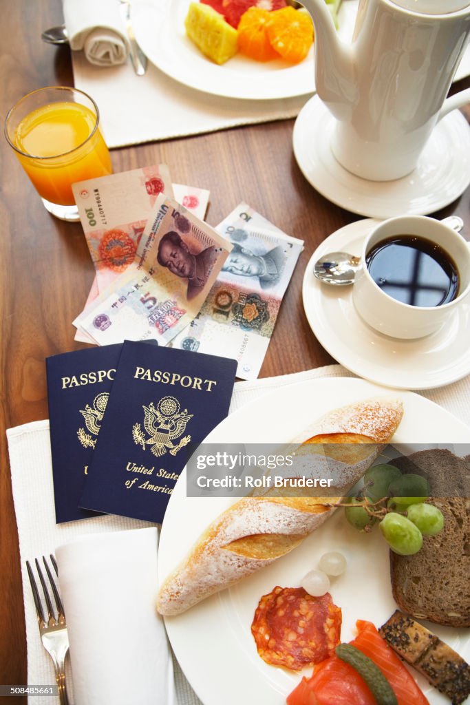 Passports, money and food on breakfast table