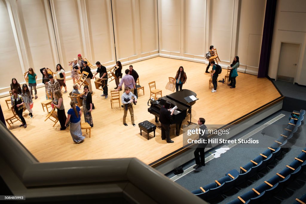 Conductor arranging choir on stage