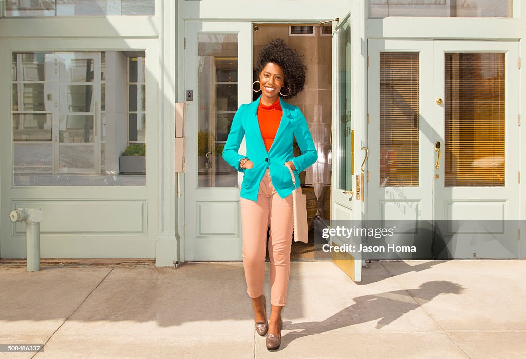 Mixed race woman standing on city sidewalk