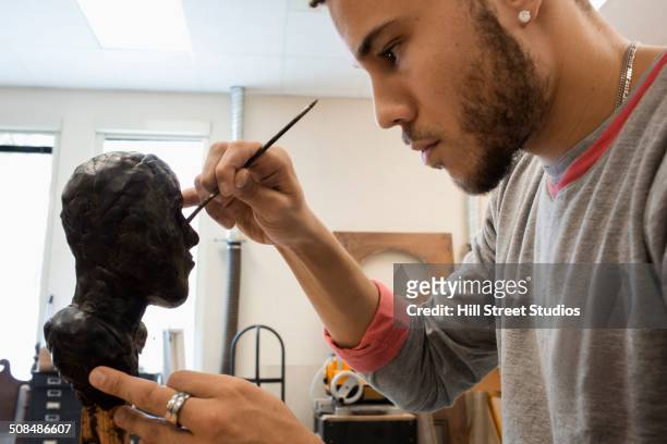 mixed race student carving wax figure in class - black sculptor stock pictures, royalty-free photos & images