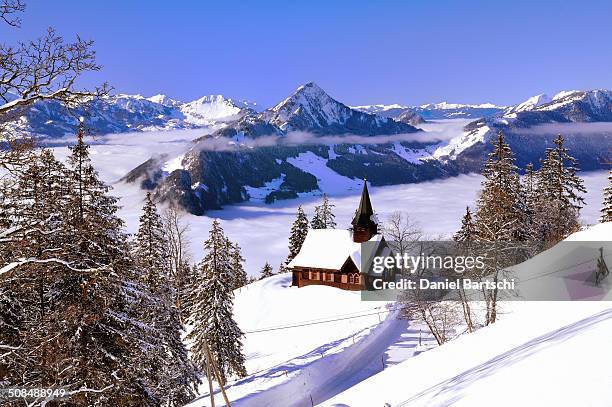 chapel in winter with view on the hochflue and the central swiss alps, haggenegg, canton of schwyz, switzerland - schwyz stock pictures, royalty-free photos & images