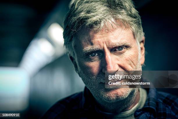 homeless senior adult man with beard in subway tunnel - homeless man stock pictures, royalty-free photos & images
