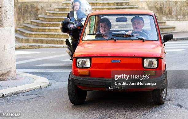 sicily, italy: senior in beret driving little red fiat - modica sicily stock pictures, royalty-free photos & images