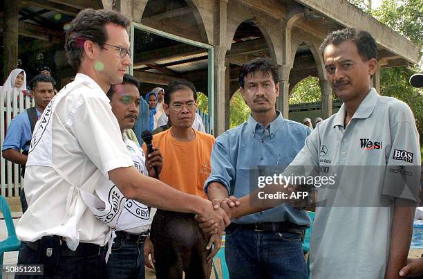 Released hostage and Indonesian local cameraman, Ferry Santoro , shakes hands with Gotzon Onandia of the International Committee of the Red Cross as...