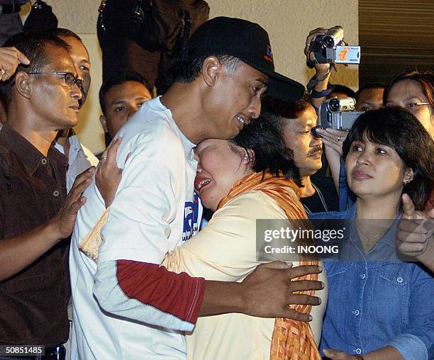 Indonesian local cameraman Ferry Santoro hugs his wife at Sukarno-Hatta airport in Jakarta, 18 May 2004, following his return from Aceh after being...