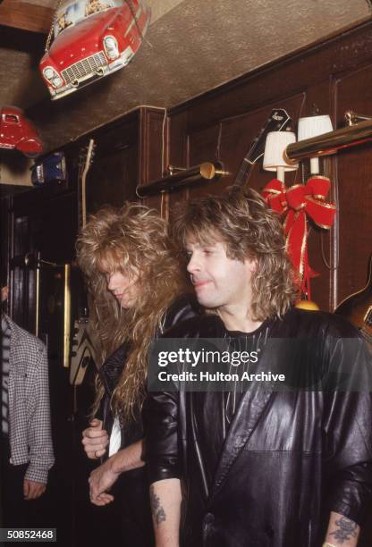 British heavy metal singer Ozzy Osbourne and bassist Rudy Sarzo stand inside a bar, 1980s.