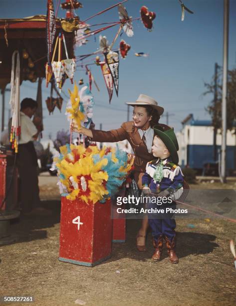 American actress, singer and songwriter Dale Evans at the circus with a small boy, circa 1947. She was the second wife of actor Roy Rogers.