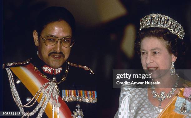 Queen Elizabeth II, wearing a diamond and pearl tiara and the jubilee necklace, attends a banquet with King Birendra during her visit to Nepal on...