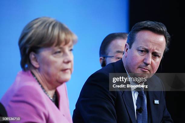 Angela Merkel, Germany's chancellor, left, speaks as David Cameron, U.K. Prime minister listens on during a news conference at the Supporting Syria...