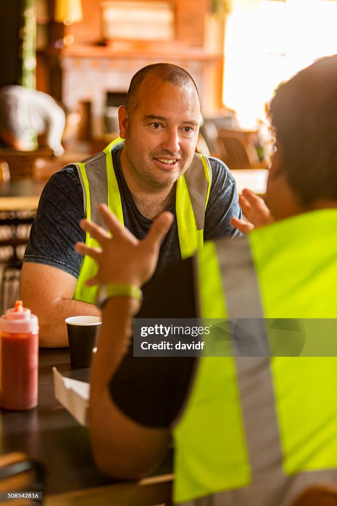 Workmen Relaxing With Beer After Work in High Visibility Clothes