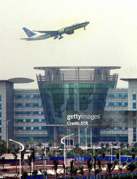 Chinese Southern Airlines plane takes off over the new Baiyun International Airport in the southern Chinese city of Guangzhou, 18 May 2004, for its...