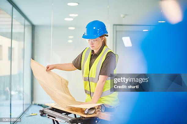 female carpenter checking the plans - blue ventilation stock pictures, royalty-free photos & images