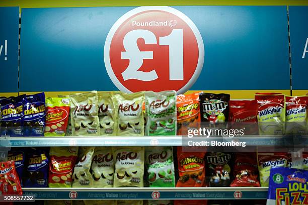 One pound sterling sign sits above chocolate snacks at Poundland Group Plc store in Leigh, U.K., on Thursday, Feb. 4, 2016. U.K. Like for like sales...