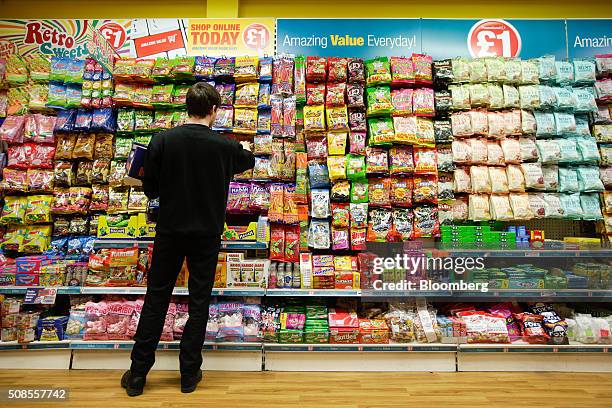 An employee stacks snacks at a Poundland Group Plc store in Leigh, U.K., on Thursday, Feb. 4, 2016. U.K. Like for like sales at mid-market retailers...