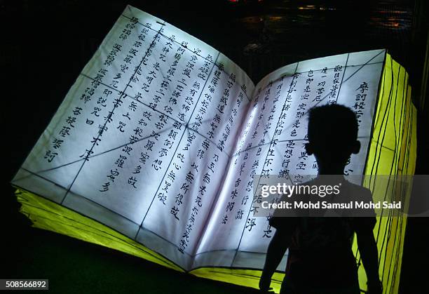 Malaysian-Chinese child is seen silhouetted inside the Jenjarom temple decorated with Chinese religious book lanterns ahead of Lunar New Year of the...