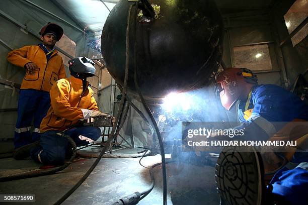 Picture shows employees working at the Siba oil field from Egypt's state-owned Petrojet in southern Iraq, 30 kilometres southern of Basra, on...