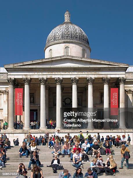 View of the National Portrait Gallery in Trafalgar square with a lot of tourists crowed the place in a sunny day.