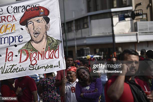 Pro-government supporters carry a banner depicting former Venezuelan President Hugo Chavez during a rally to commemorate the 24th anniversary of...