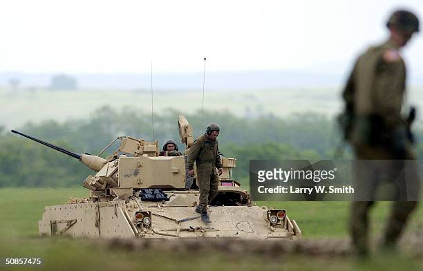 Soldiers get out of their Bradley Fighting Vehicle from the 1st Battalion, 41st Infantry, 3rd Brigade, 1st Armored Division while another soldier...