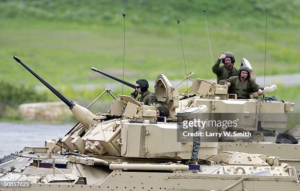 Soldier from the 1st Battalion, 41st Infantry, 3rd Brigade, 1st Armored Division gives a thumbs up to a passing soldier in a Bradley Fighting Vehicle...