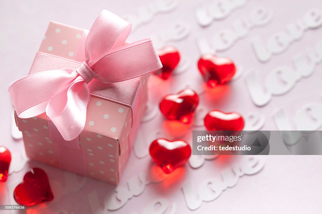 Rote Herzen und Geschenk-box auf Rosa Hintergrund