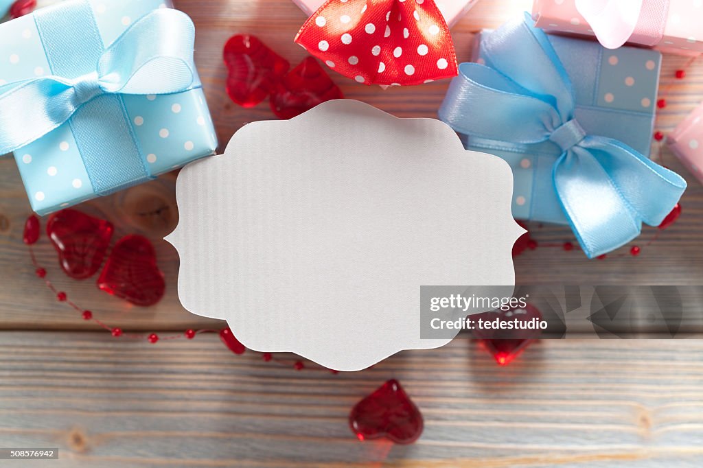 Blank label and gift boxes on wooden background