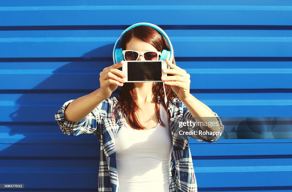 Girl makes self-portrait on smartphone listens music, screen phone