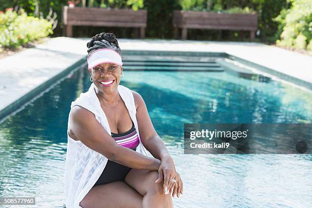 mature african american woman sitting by pool - black people in bathing suits stock pictures, royalty-free photos & images