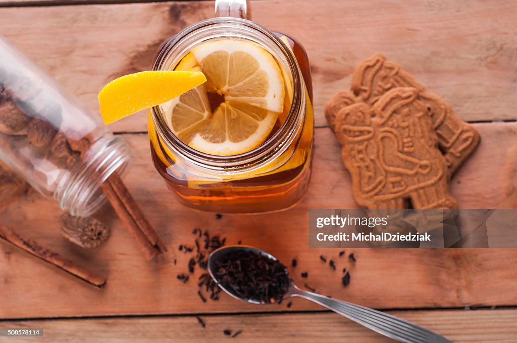 Hot spiced tea in jar on wooden table