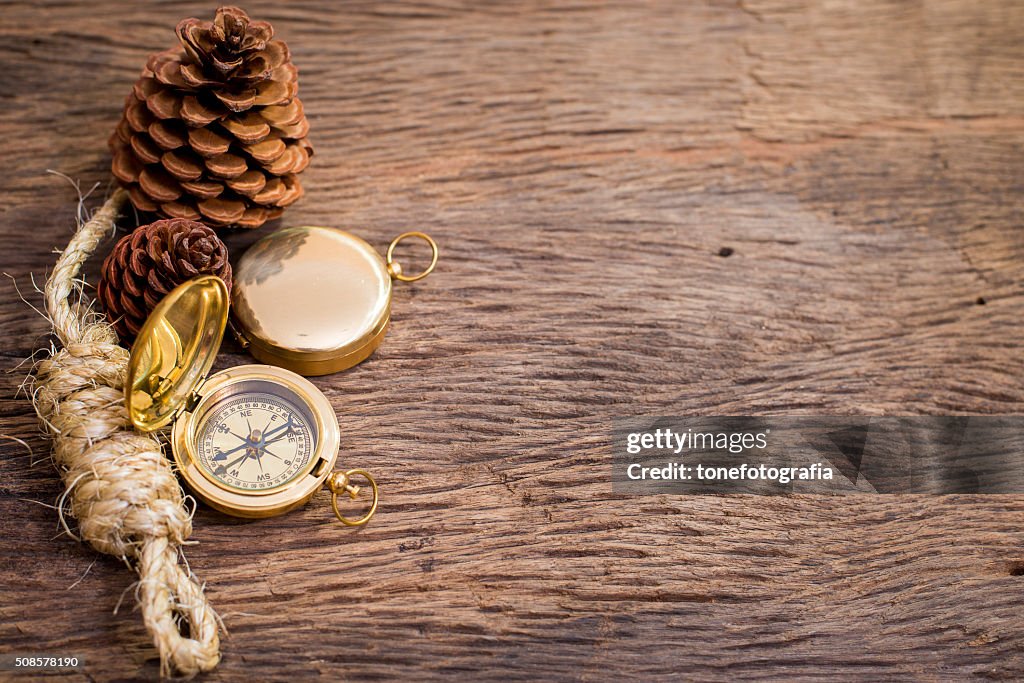 Old Compass and rope on wood background