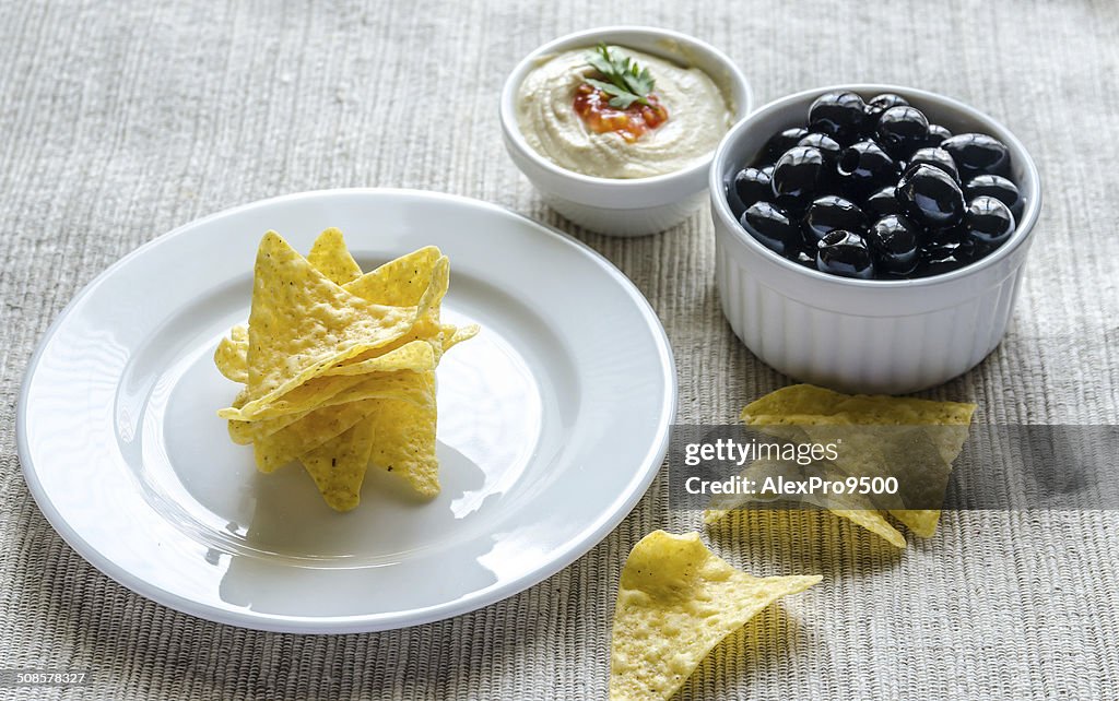 Corn chips with hummus and olives