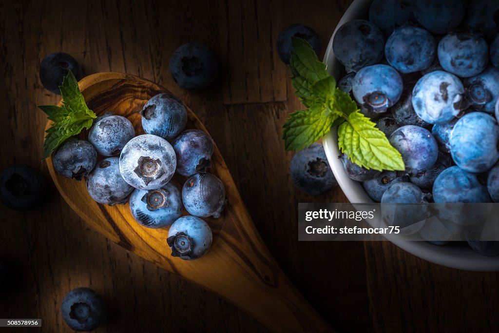 Fresh blueberry on a wooden table and bowl