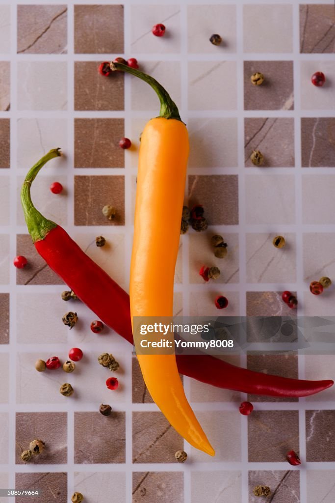 Two chili peppers on ceramic tile
