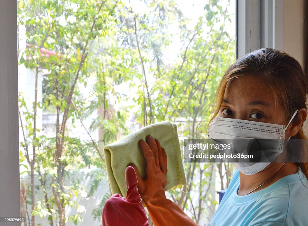 Asiatique femme nettoyer le verre avec diligence, mais toujours raffinés