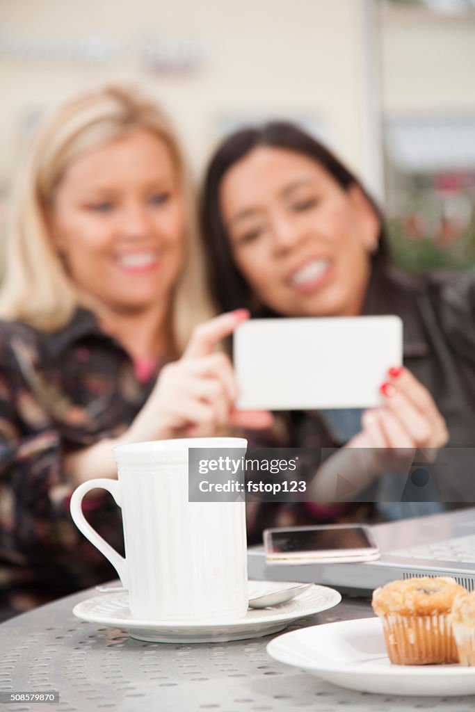 Friendship.  Women take selfies or view videos on cell phone.