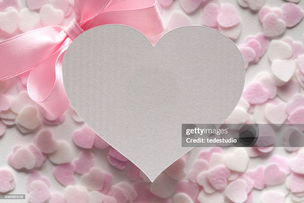 Shape of heart, pink bow and many hearts in background