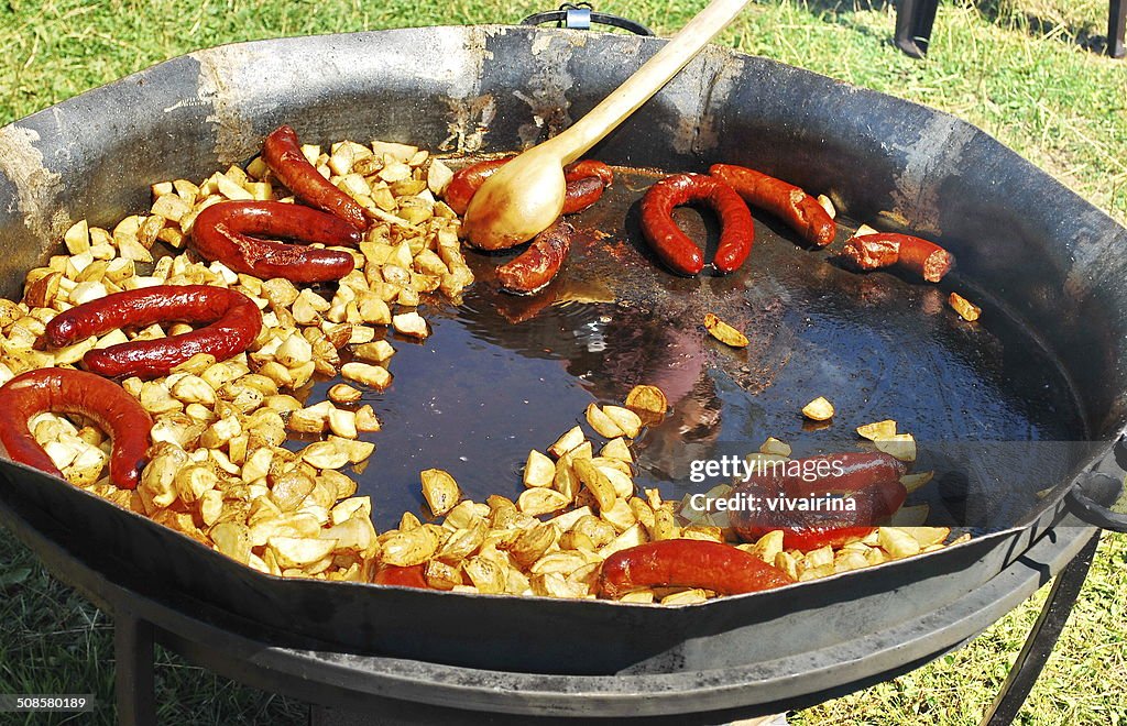 French fries and sausages in a pan