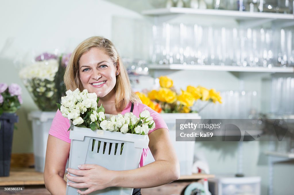 Femme travaillant dans fleuriste transporter bin
