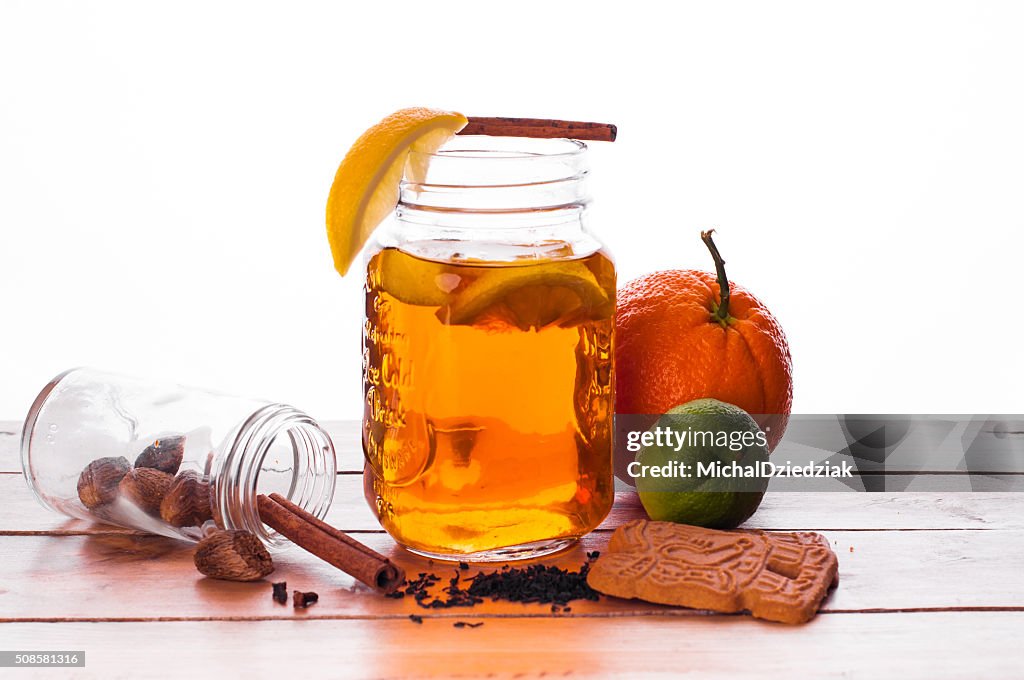 Hot spiced tea in jar on wooden table