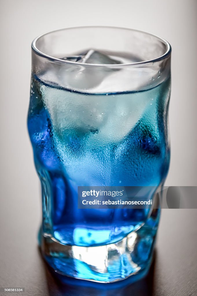 Blue shot glass with ice and condensation