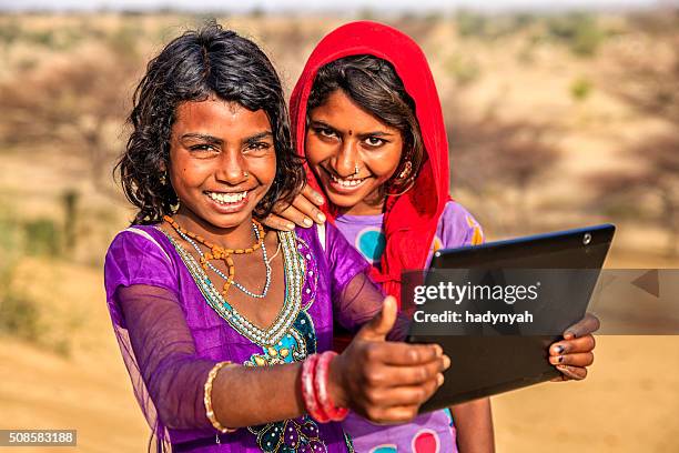 happy indian young girls using digital tablet, desert village, india - rajasthani youth stock pictures, royalty-free photos & images