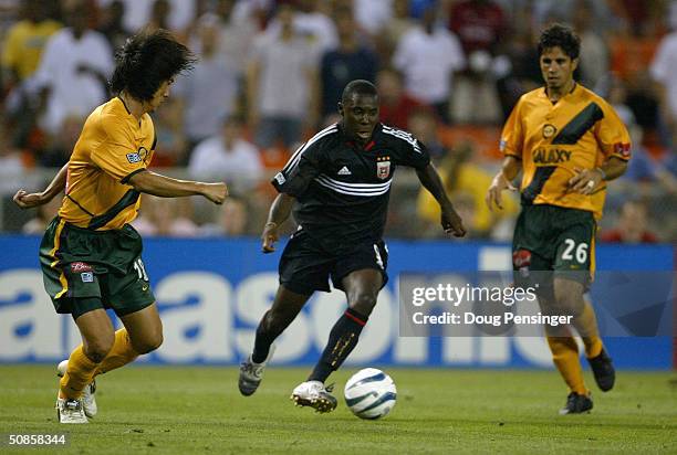 Freddy Adu of DC United controls the ball against Hong Myung-Bo and Marcelo Saragosa of the Los Angeles Galaxy enroute to his unassisted goal in the...