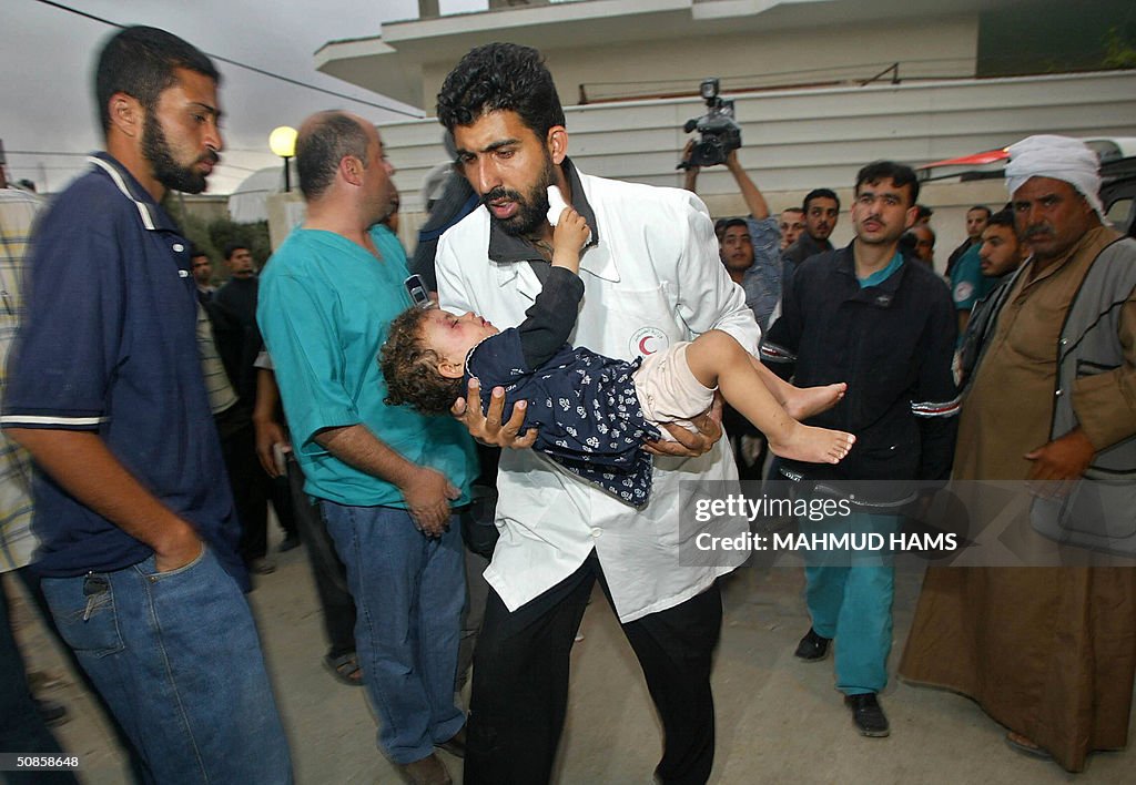 A Palestinian medic carries a wounded ch