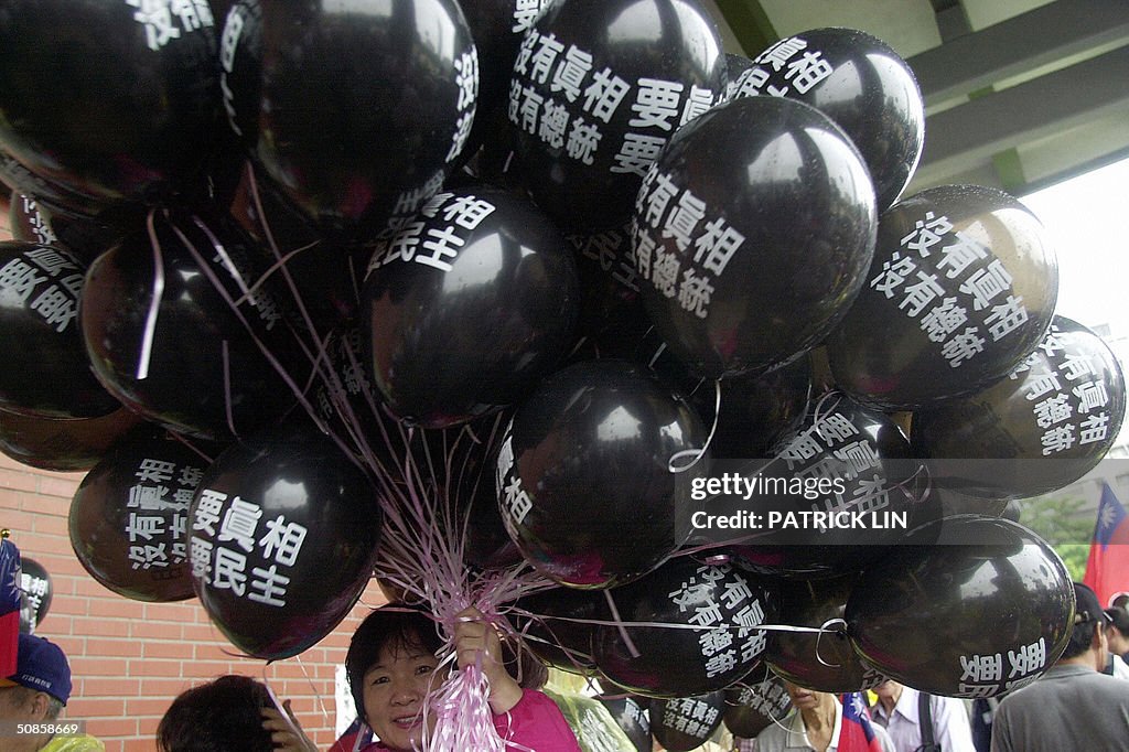 An opposition supporter holds a bundle o