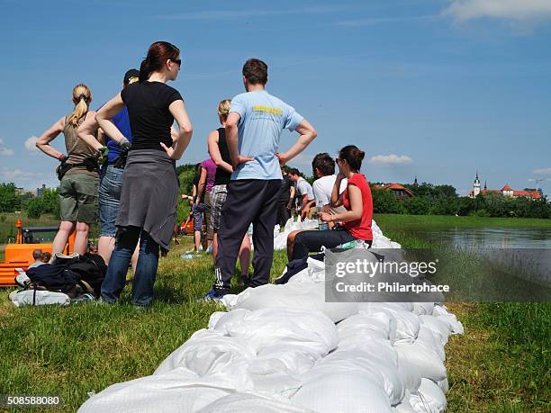 menschen kämpfen flut wasser - sandbag stock-fotos und bilder