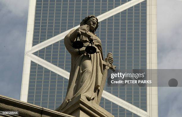 The blind-folded statue of Justice represented by the Greek goddess Themis sits atop Hong Kong's Legistlative Council building 20 May 2004 as the...